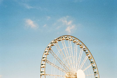 Low angle view of ferris wheel against blue sky