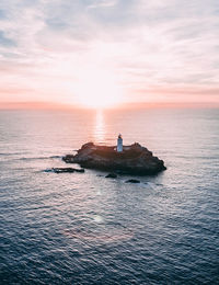 Aerial view of lighthouse amidst sky during sunset
