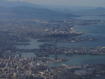 High angle view of city by sea against sky