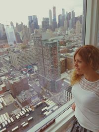 Young woman looking at modern buildings in city