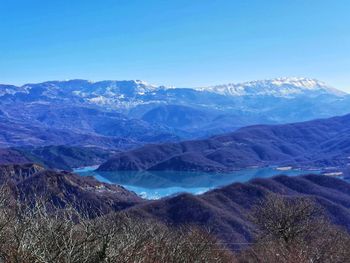 Scenic view of snowcapped mountains against blue sky