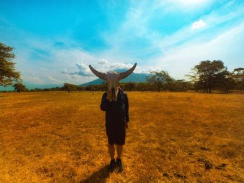 Full length of man standing on field against sky