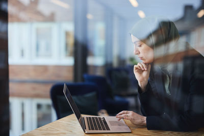 Woman in cafe using laptop