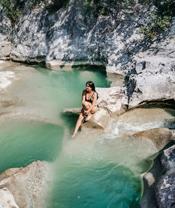 High angle view of friends on rock formation in water