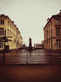 Woman standing in city against clear sky