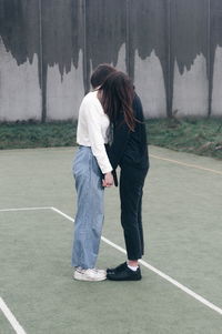 Rear view of couple standing against the wall