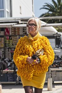 Full length of woman standing against yellow wall