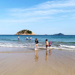 People on beach against sky