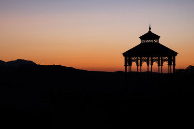 Silhouette building against sky during sunset