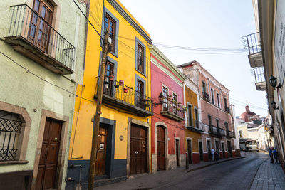 Street amidst buildings against sky in city