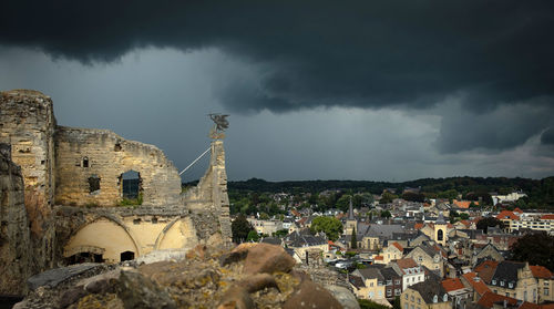 Buildings in city against cloudy sky