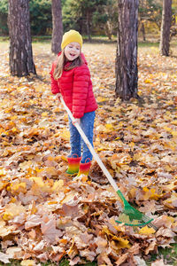 Girl raking leaves during autumn