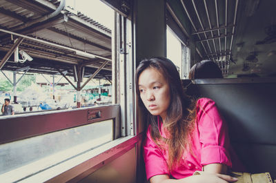 Sad woman sitting by window in train