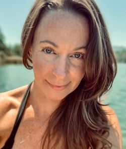 Close-up portrait of woman against lake