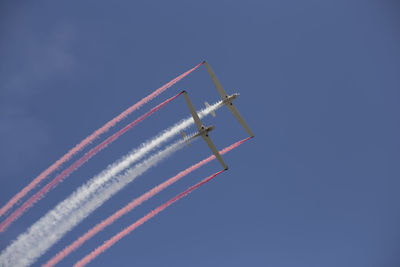 Low angle view of airplane flying against blue sky