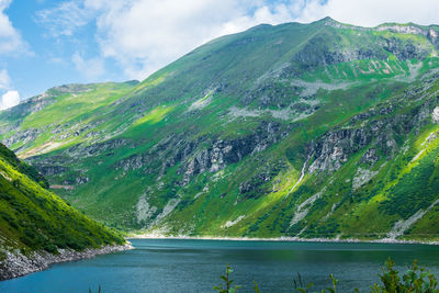 Scenic view of lake amidst mountains against sky