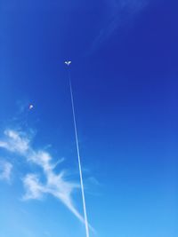 Low angle view of vapor trail against blue sky