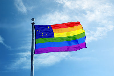 Low angle view of flag against blue sky