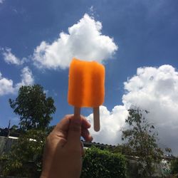 Low angle view of person holding umbrella against clear sky