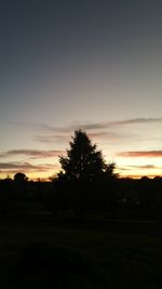 Silhouette trees on landscape against sky during sunset