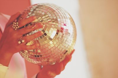 Midsection of woman holding disco ball