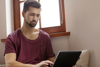 Young man using mobile phone at home