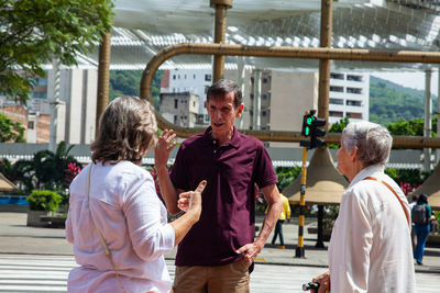 Side view of friends standing in city