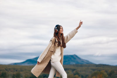 Rear view of woman standing against sky