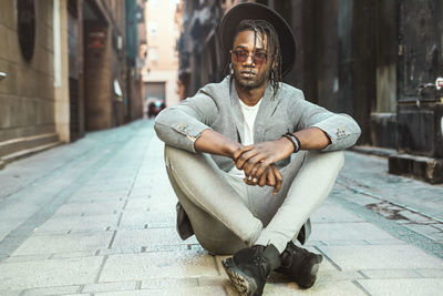 Portrait of young man sitting in city