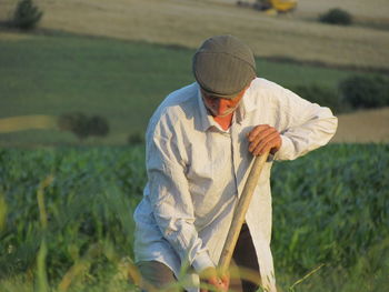 Man gardening by tool on field