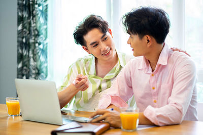 Friends using laptop at home