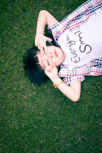 High angle portrait of woman lying on field