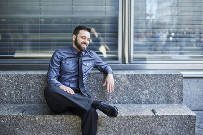 Portrait of a smiling young man sitting outdoors