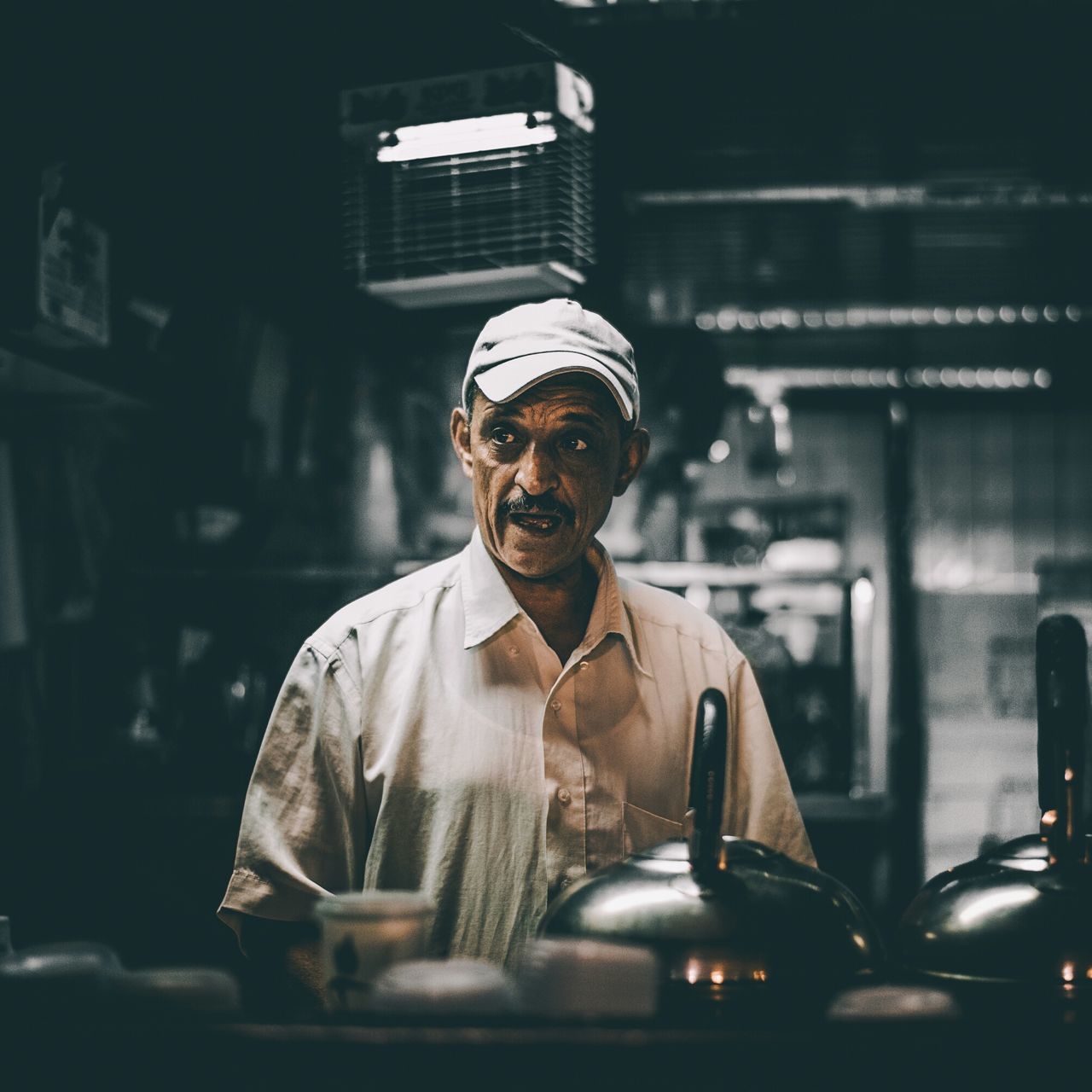 indoors, focus on foreground, human representation, statue, front view, illuminated, night, close-up, sitting, lifestyles, young men, religion, incidental people, portrait, reflection, men, leisure activity