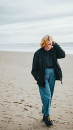 Full length of young woman standing on beach