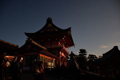 Low angle view of temple against building at dusk