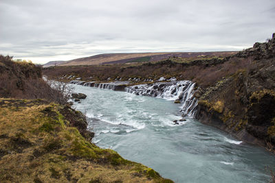 Scenic view of waterfall against sky