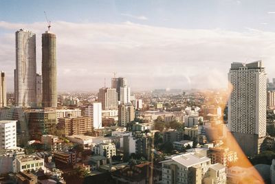 Aerial view of buildings in city against sky