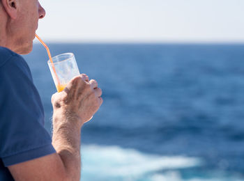 Man having drink by sea