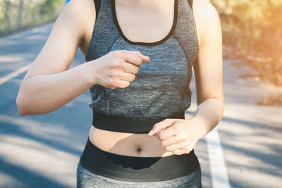 Midsection of woman jogging on road