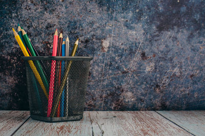 Close-up of multi colored pencils on wooden wall