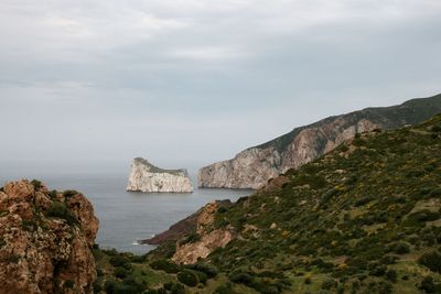 Scenic view of sea and mountains against sky scoglio pan di zucchero masua