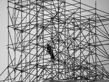 Low angle view of man at construction site against sky