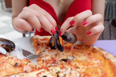 Close-up of hand holding pizza