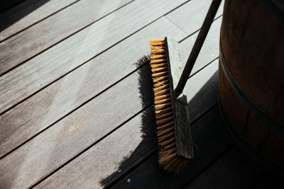 High angle view of broom on wooden floor