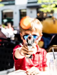 Midsection of woman holding camera on table at restaurant