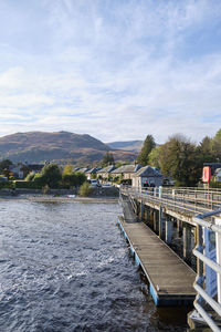 Scenic view of river by buildings against sky