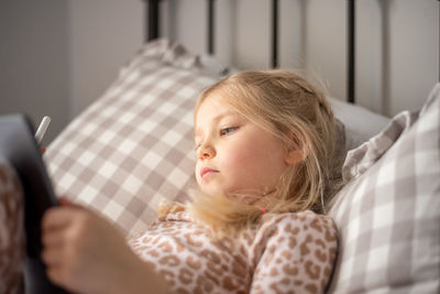 Girl looking at camera while sitting on bed