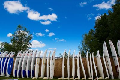 Surfboards in row against blue sky