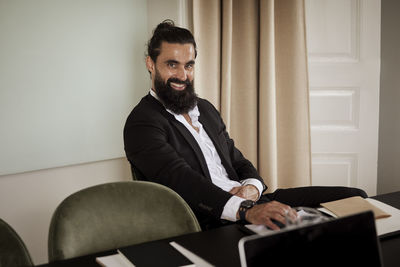 Side view of man using laptop at home